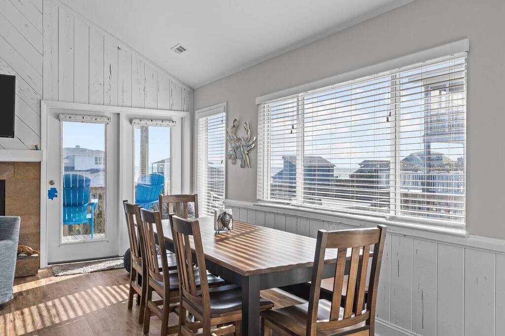 Gather around this charming dining table where morning coffee tastes better with ocean breeze flowing through coastal-themed windows.
