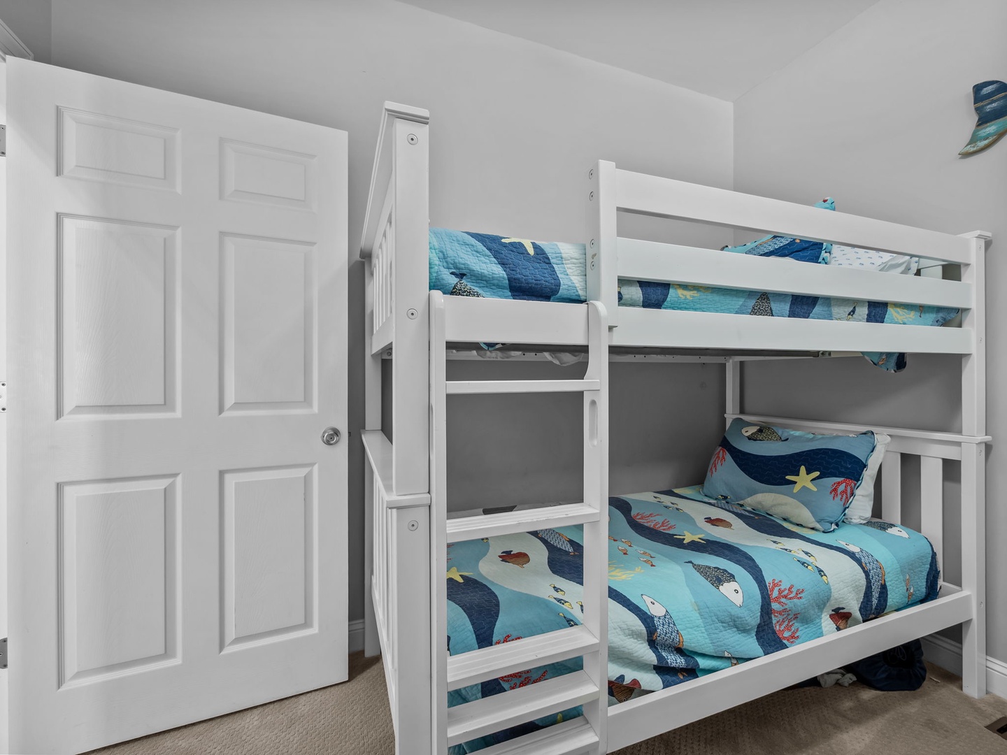 Your kids will love these cozy bunk beds with playful ocean-themed bedding, perfect for bedtime stories and adventures.