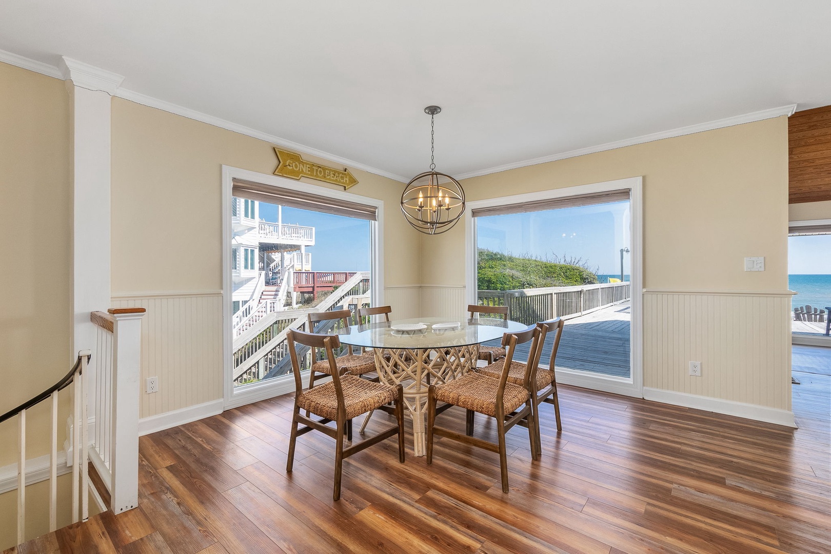 Savor meals in your bright dining space with stunning ocean views through expansive windows and warm coastal charm.