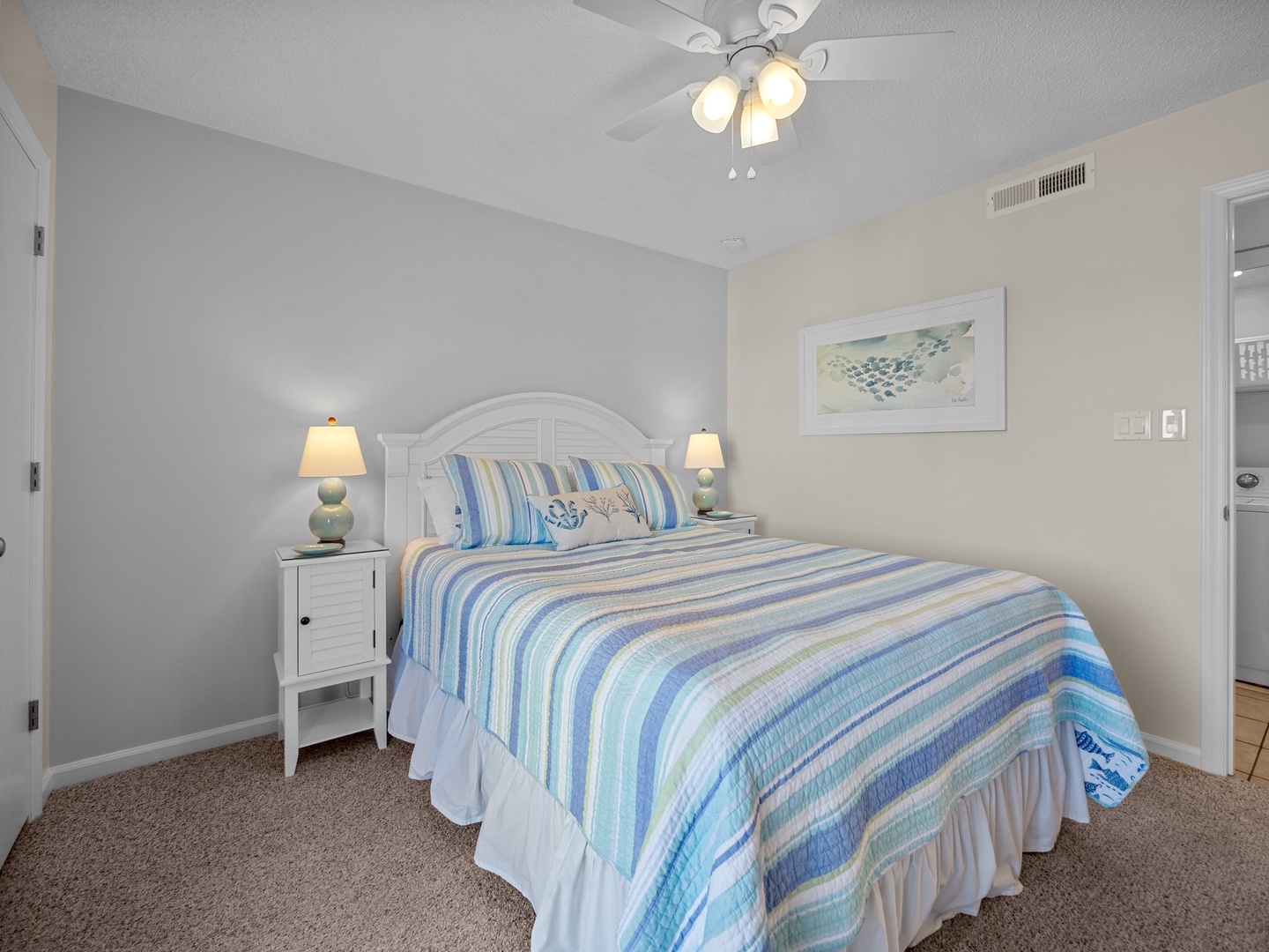 Drift off to peaceful sleep in this coastal-inspired bedroom, complete with soothing blue linens and gentle ceiling fan.