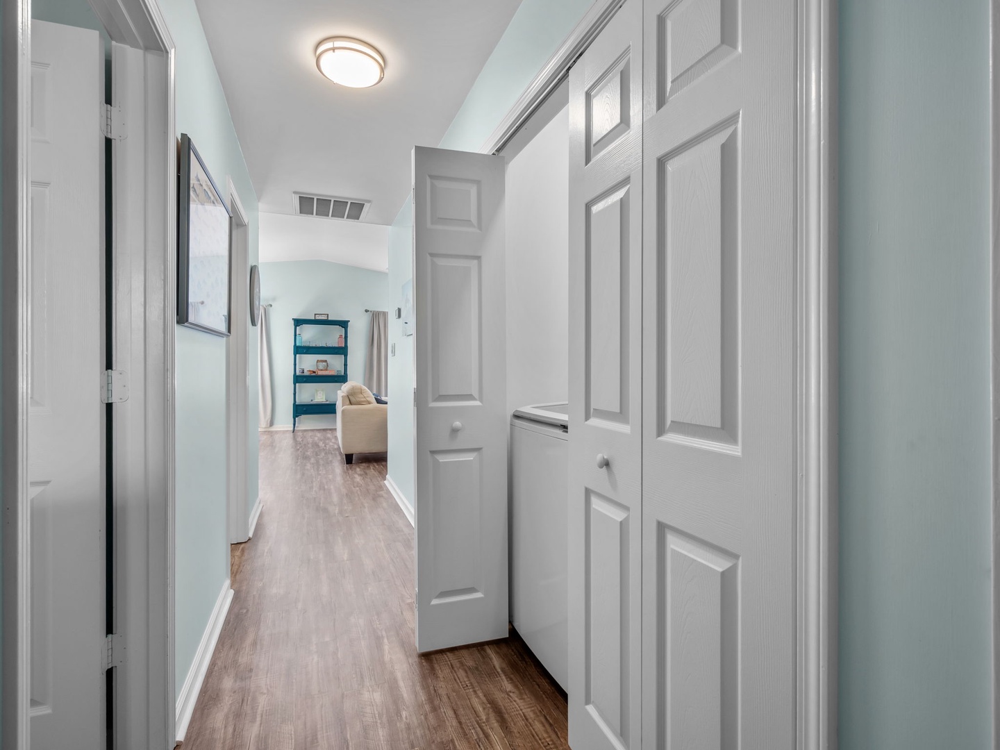 Step into your tranquil hallway with soft mint walls and gleaming hardwood floors leading to your cozy living spaces.