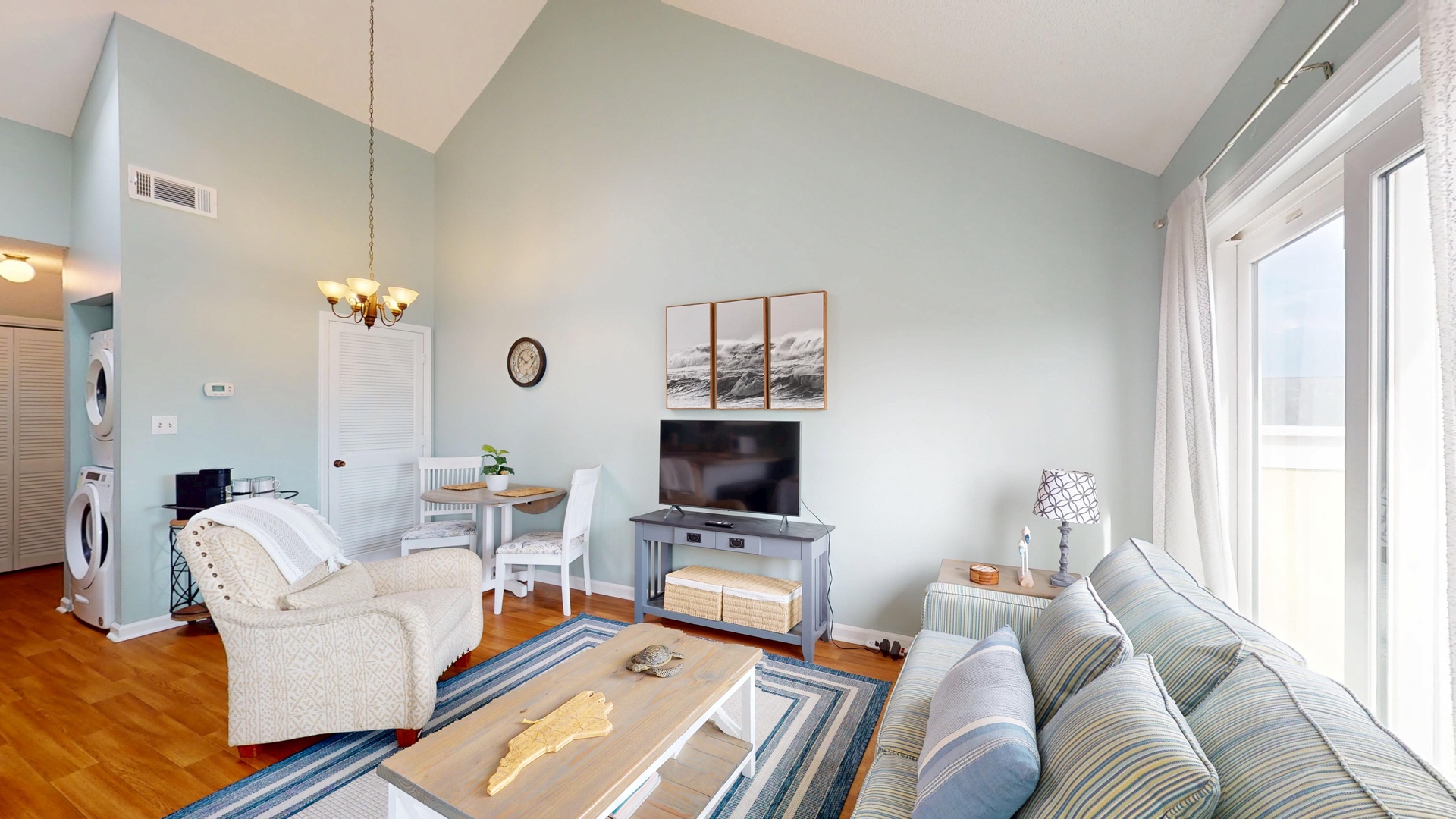 Relax in your bright, coastal-inspired living space with comfortable seating and large windows that fill the room with natural light.