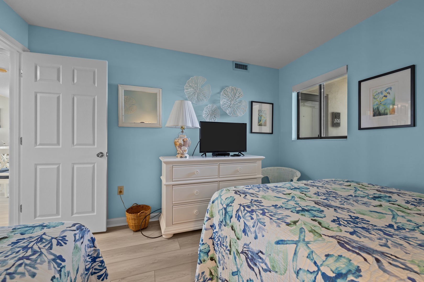 Drift off in this soothing coastal bedroom where ocean-blue walls and tropical bedding create your perfect seaside sanctuary.