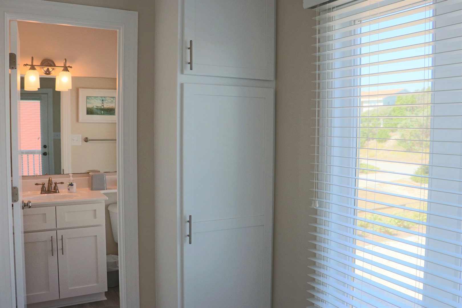 Your bright bedroom features built-in storage and connects to your private bathroom with modern vanity and warm lighting.
