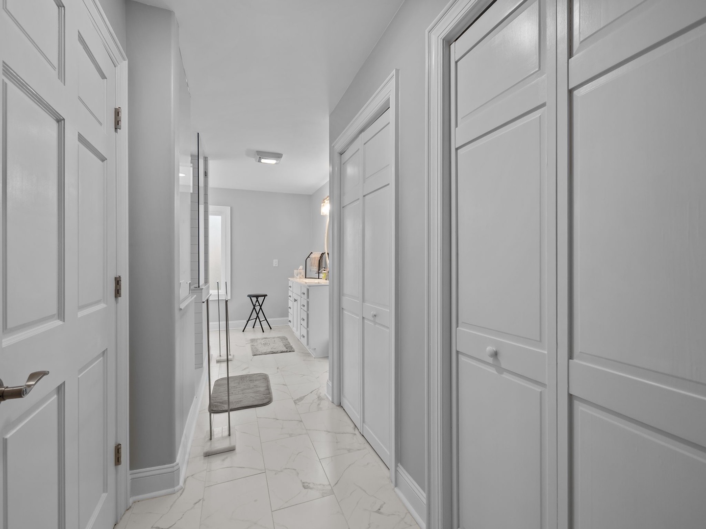 Step into your elegant marble hallway where crisp white doors lead to spacious rooms, creating a refined home-away-from-home experience.