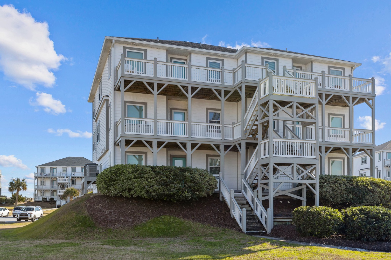 Elevated beachside property featuring multiple balconies and coastal architecture in a serene oceanfront community.