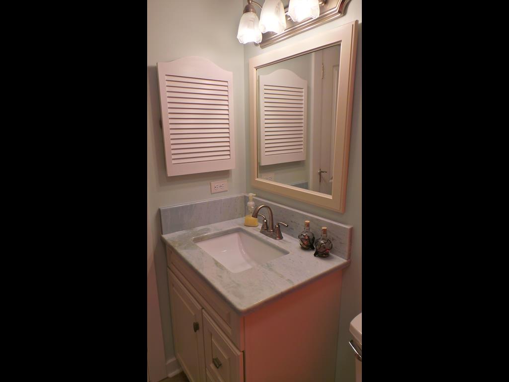 Freshen up in your private bathroom featuring elegant marble countertops, warm lighting, and thoughtful amenities for your comfort.