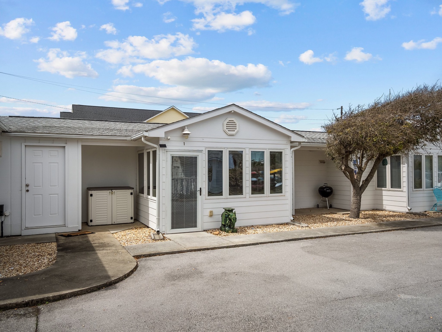 Charming beachside property featuring classic coastal architecture with bright blue skies overhead.