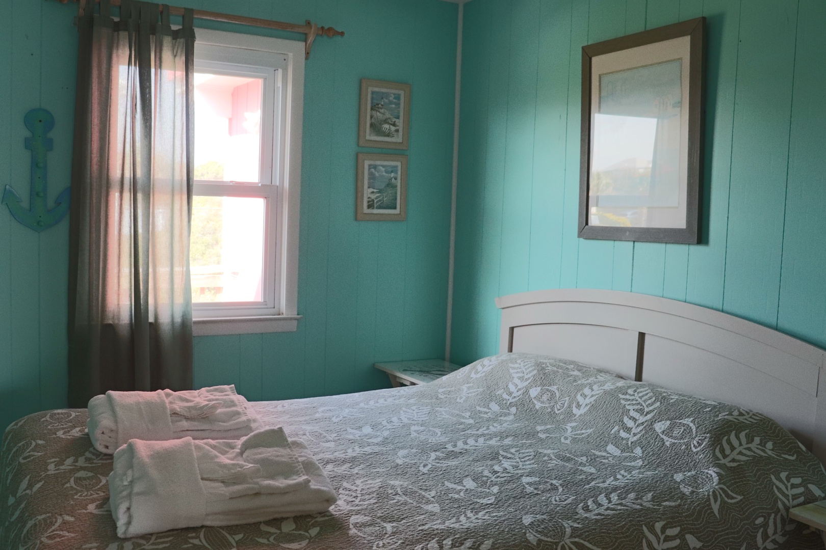 Wake up refreshed in this charming coastal bedroom with cheerful turquoise walls and crisp white linens, where morning light filters through your window.
