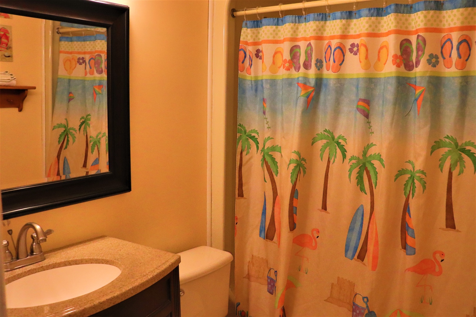 Your tropical-themed bathroom brings vacation vibes with cheerful palm tree curtains and warm lighting for refreshing moments.
