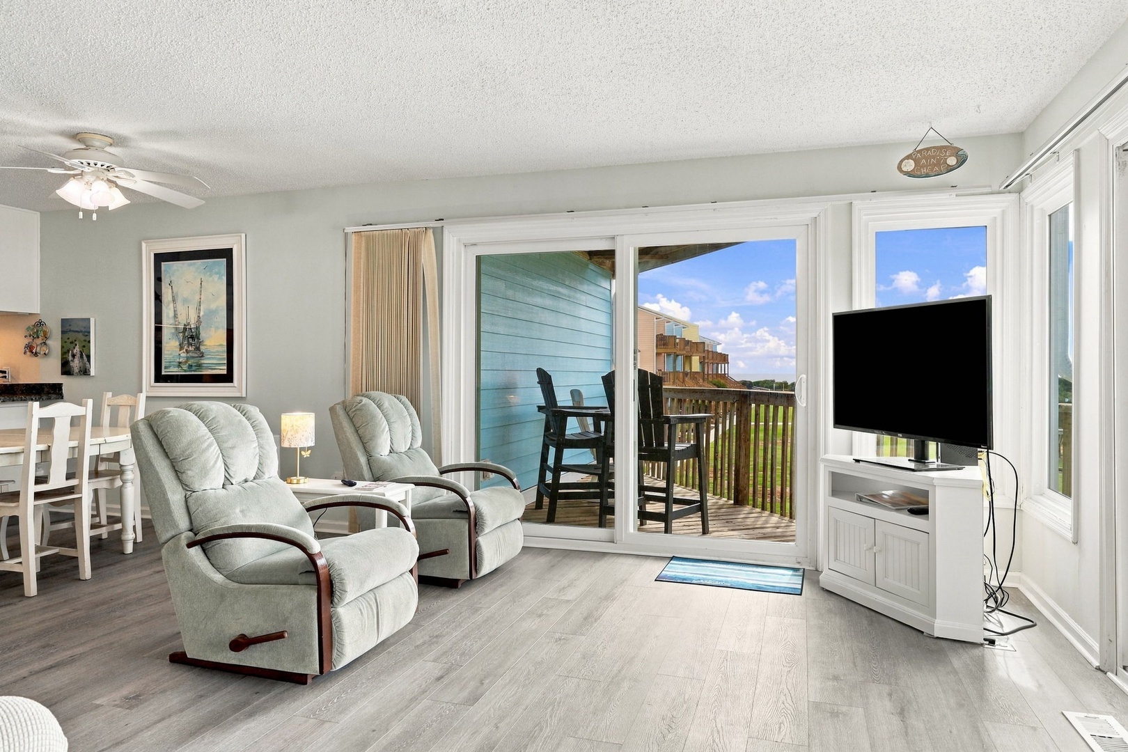 Step into your bright coastal retreat where comfortable seating invites you to relax while glass doors open to your private balcony with peaceful outdoor views.