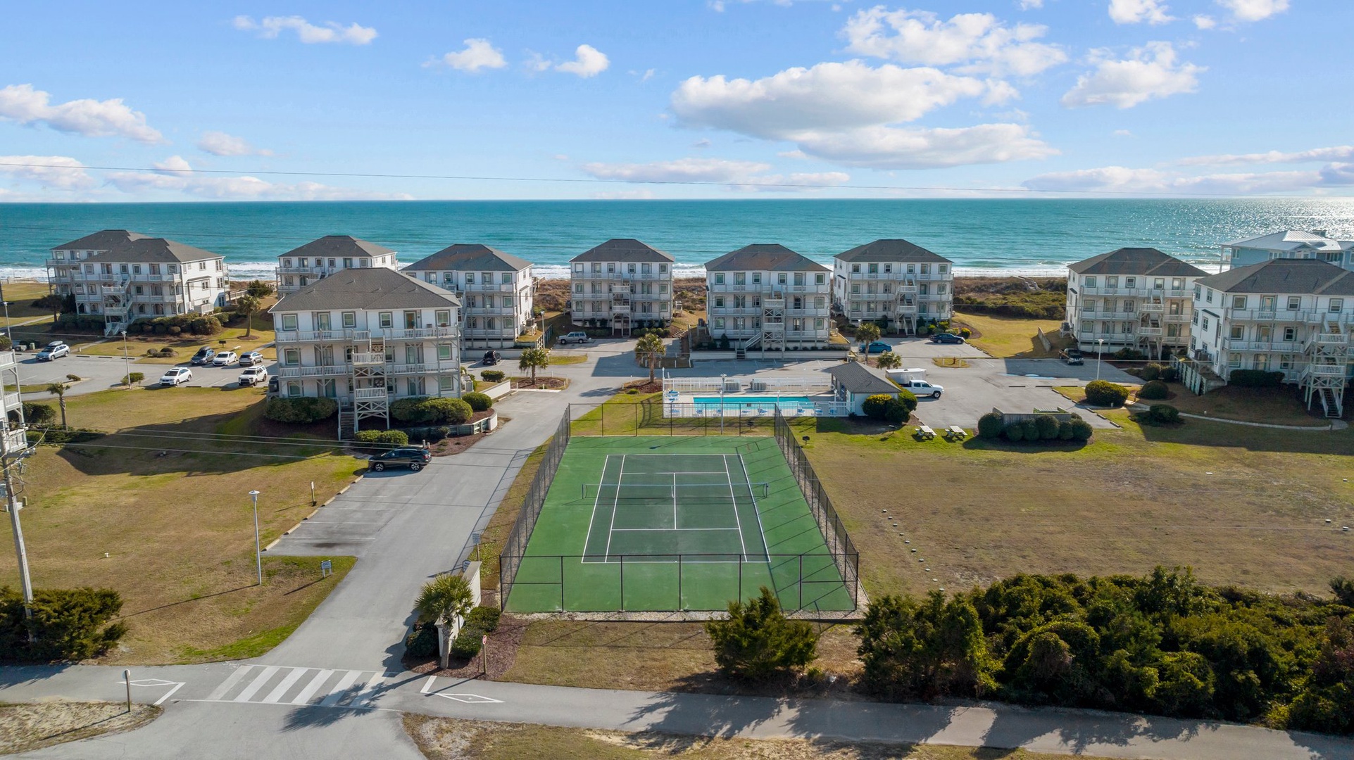 Coastal resort community featuring beachfront vacation rentals with tennis court, swimming pool, and direct ocean access.
