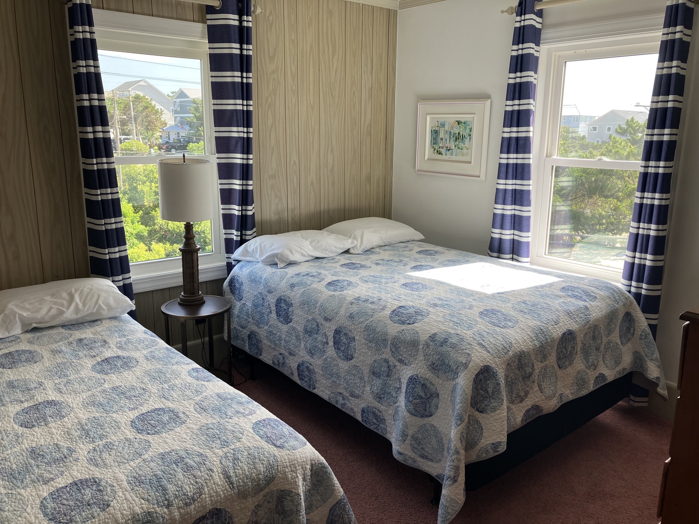Wake up to gentle sunlight streaming through your windows in this charming coastal bedroom, where twin beds await your restful nights.