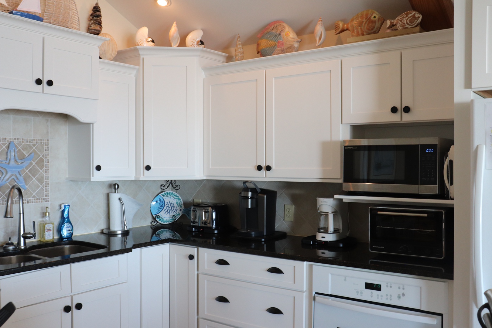 Cook your favorite meals in this fully equipped kitchen with modern appliances and charming coastal touches.