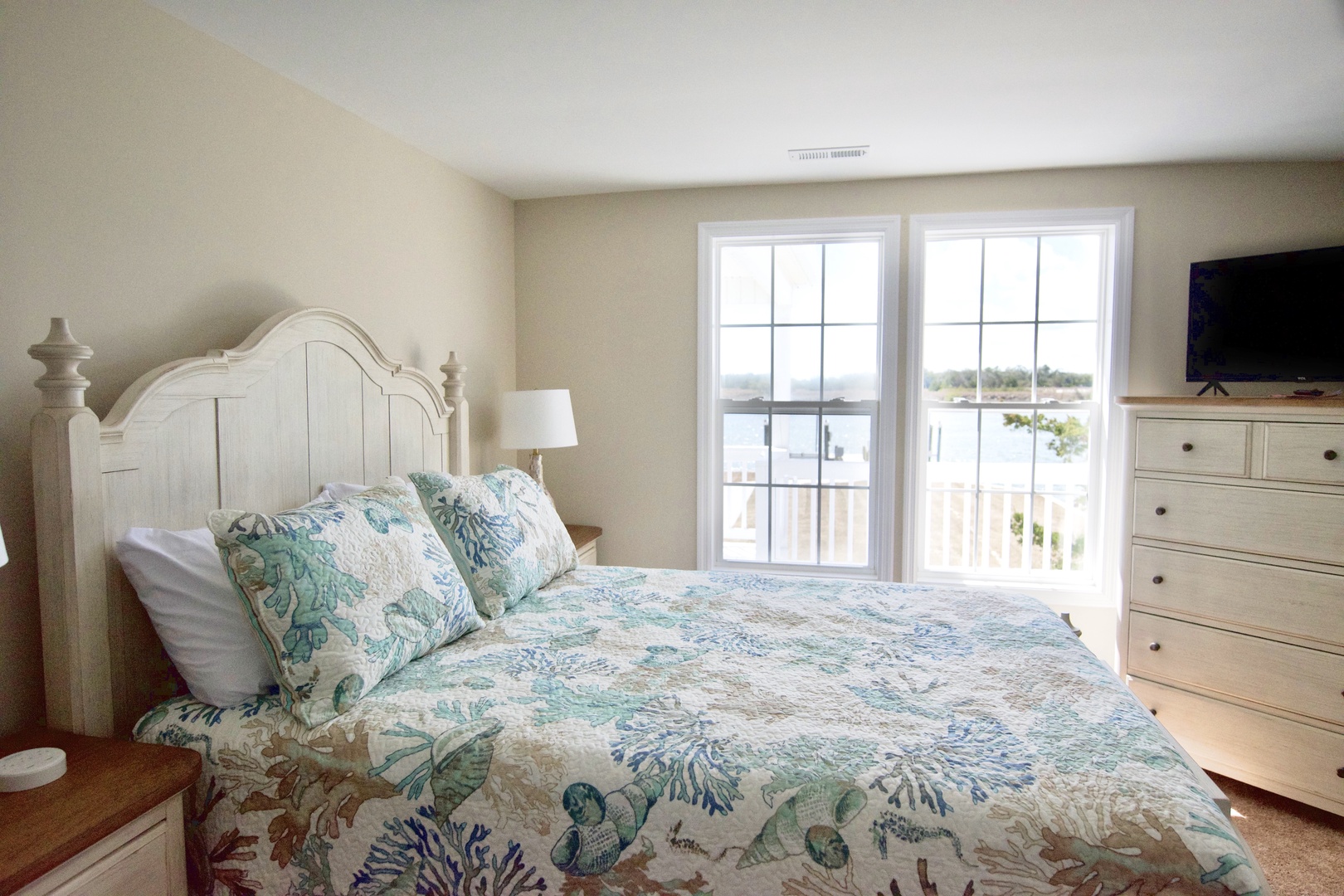 Wake up to beautiful lake views through your bedroom windows, where soft coastal decor creates a peaceful retreat.