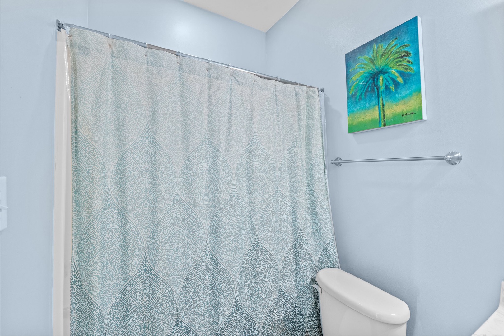 Refresh yourself in this bright, clean bathroom featuring a spacious shower with tropical artwork to inspire your vacation mood.