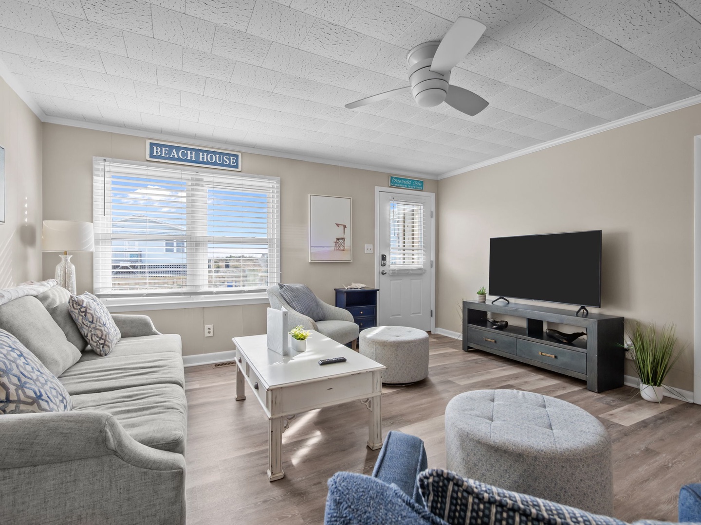 Sink into plush coastal comfort in your bright living space, complete with smart TV and gentle ceiling fan for perfect relaxation.