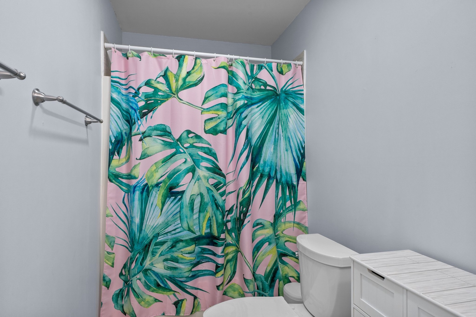 Step into your bright bathroom featuring a vibrant tropical shower curtain that adds color and personality to your daily routine.