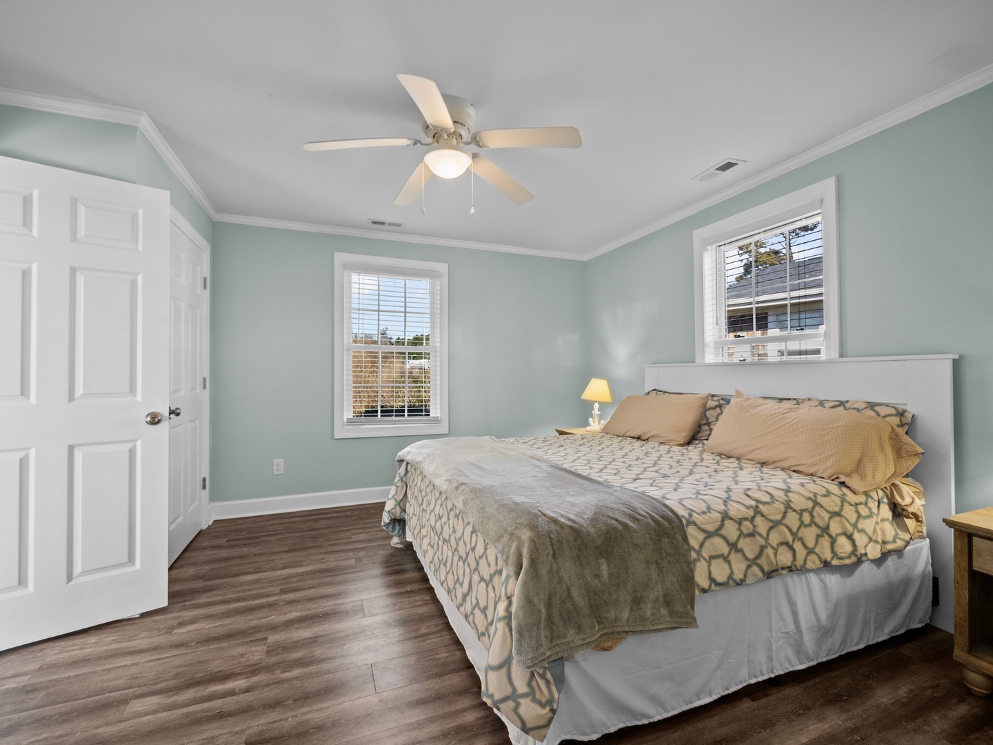 Rest peacefully in this tranquil bedroom with soft mint walls, cozy linens, and gentle ceiling fan creating your perfect sleep sanctuary.