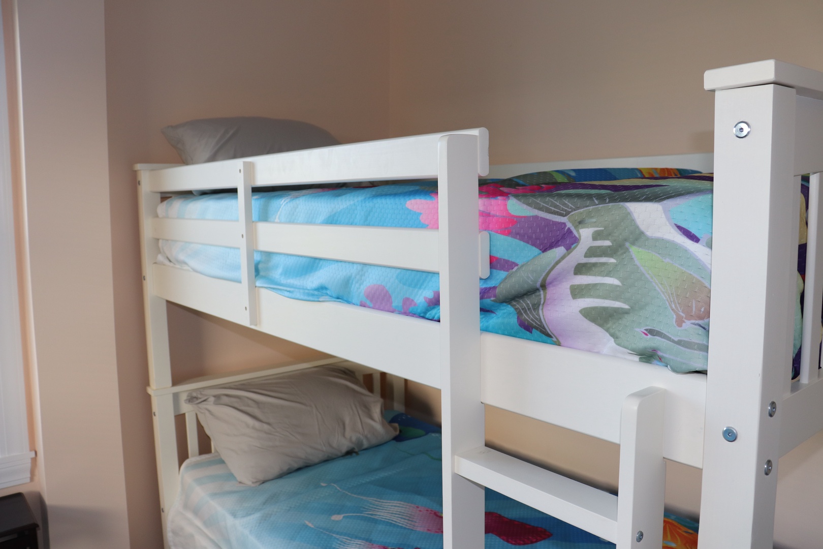 Your kids will love the cozy white bunk beds with colorful bedding, creating the perfect space for bedtime stories.