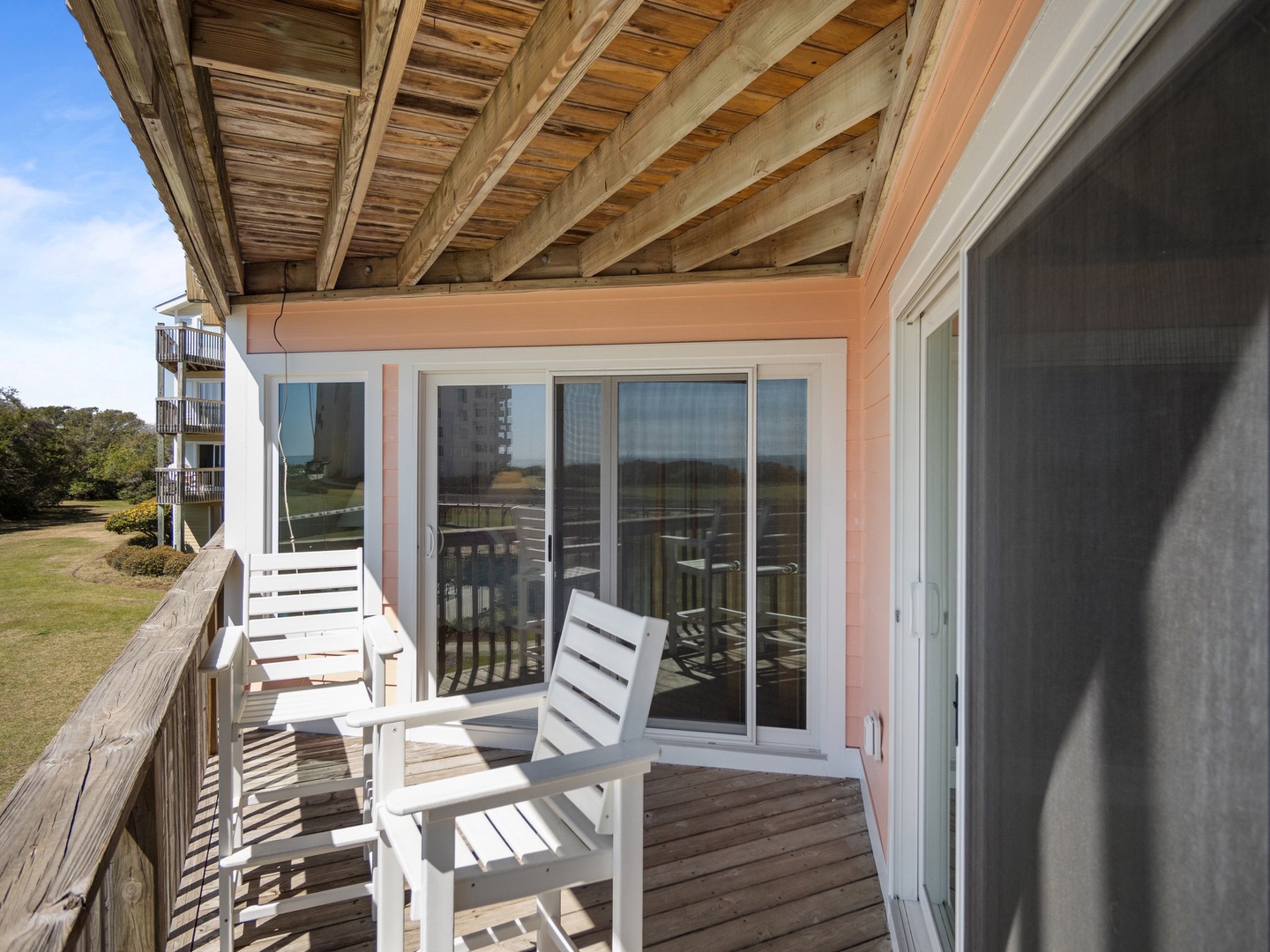 Your private balcony offers peaceful moments with comfortable seating and refreshing ocean breezes under charming wooden beams.