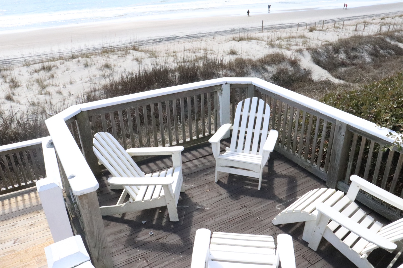 Relax on your private deck with classic Adirondack chairs, where pristine white sand dunes meet endless ocean views.