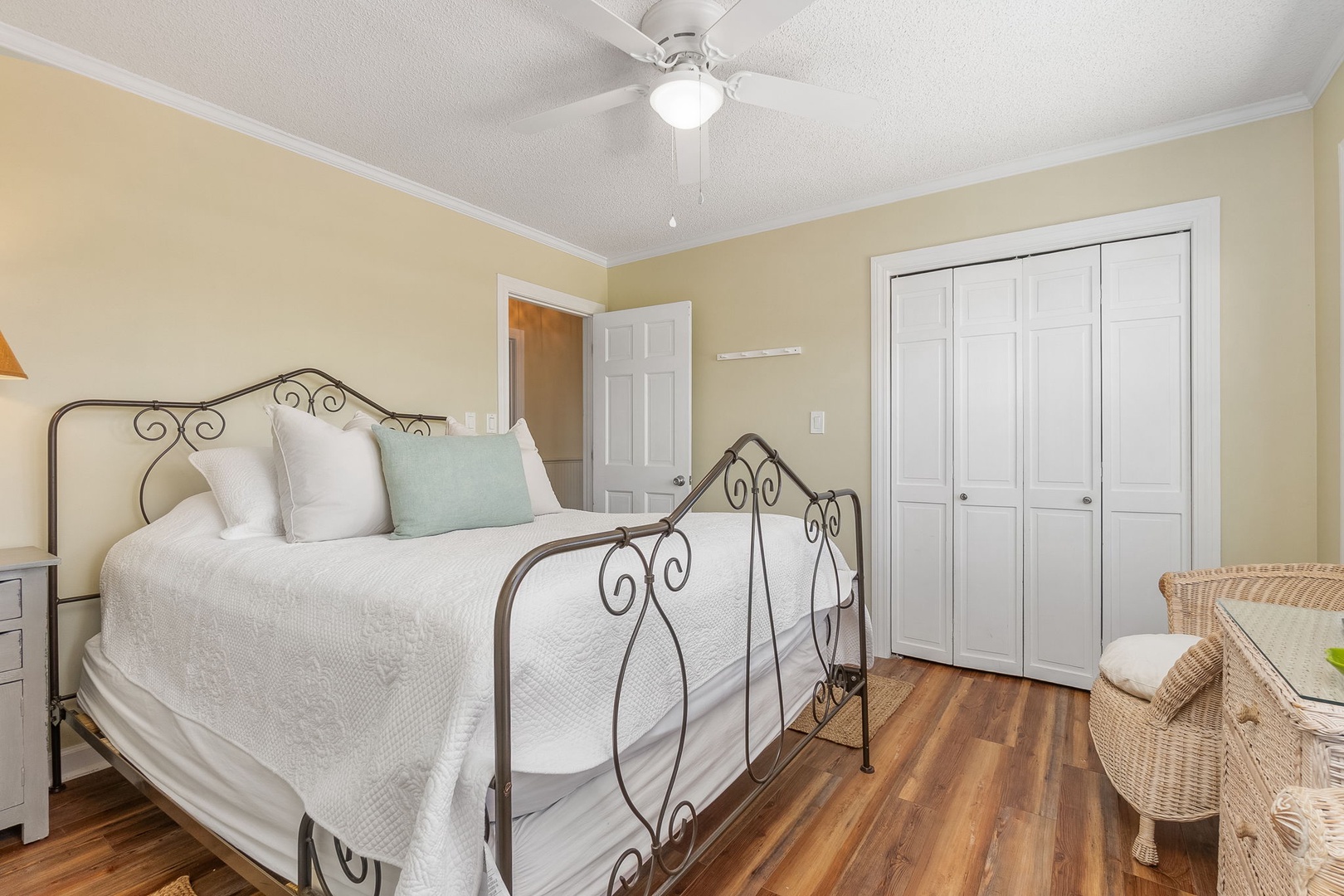 Drift off in your charming bedroom with vintage metal bed frame, soft linens, and gentle ceiling fan breeze.