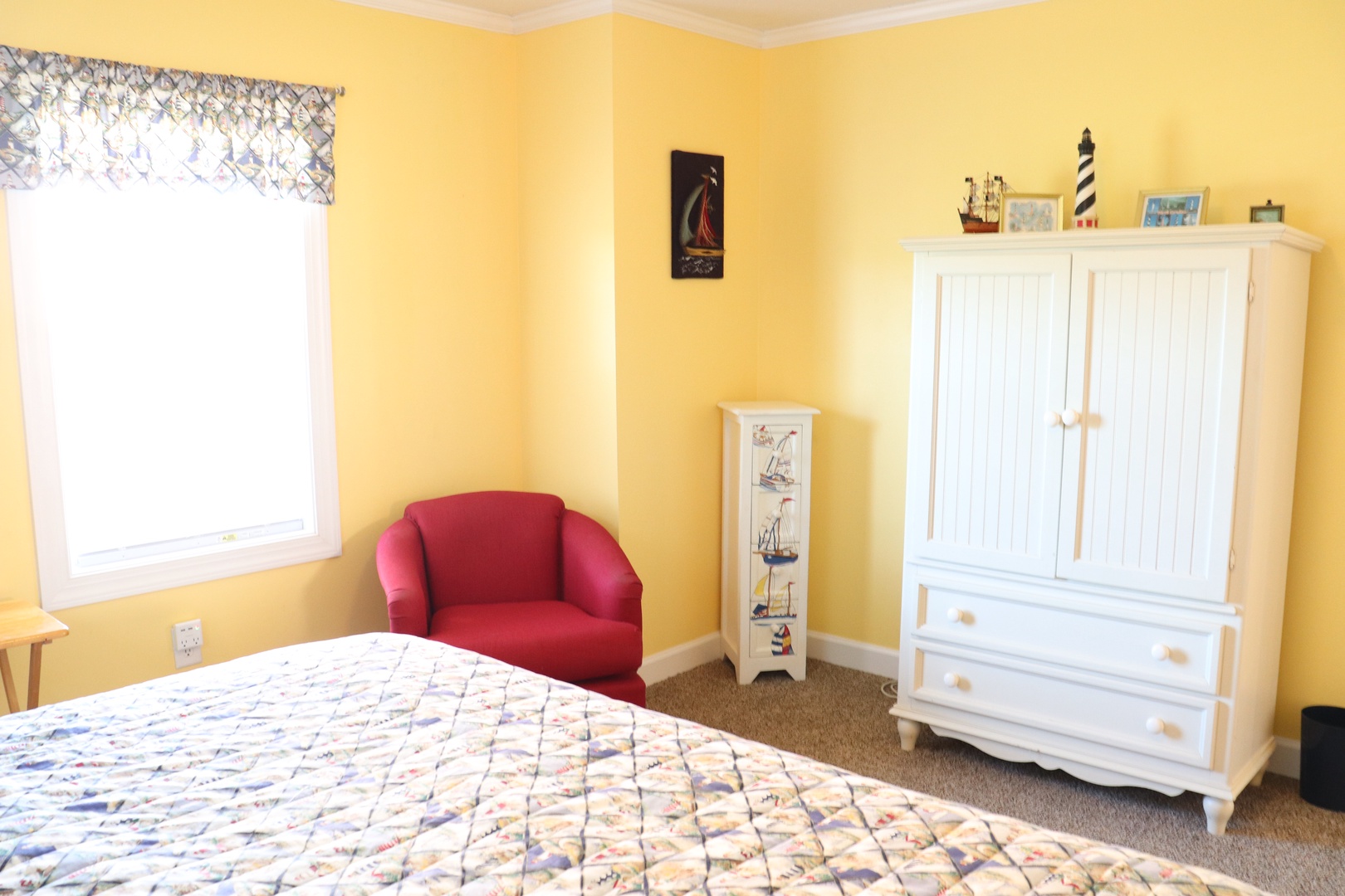 Relax in your bright, cheerful bedroom with nautical touches and a cozy reading chair by the window.