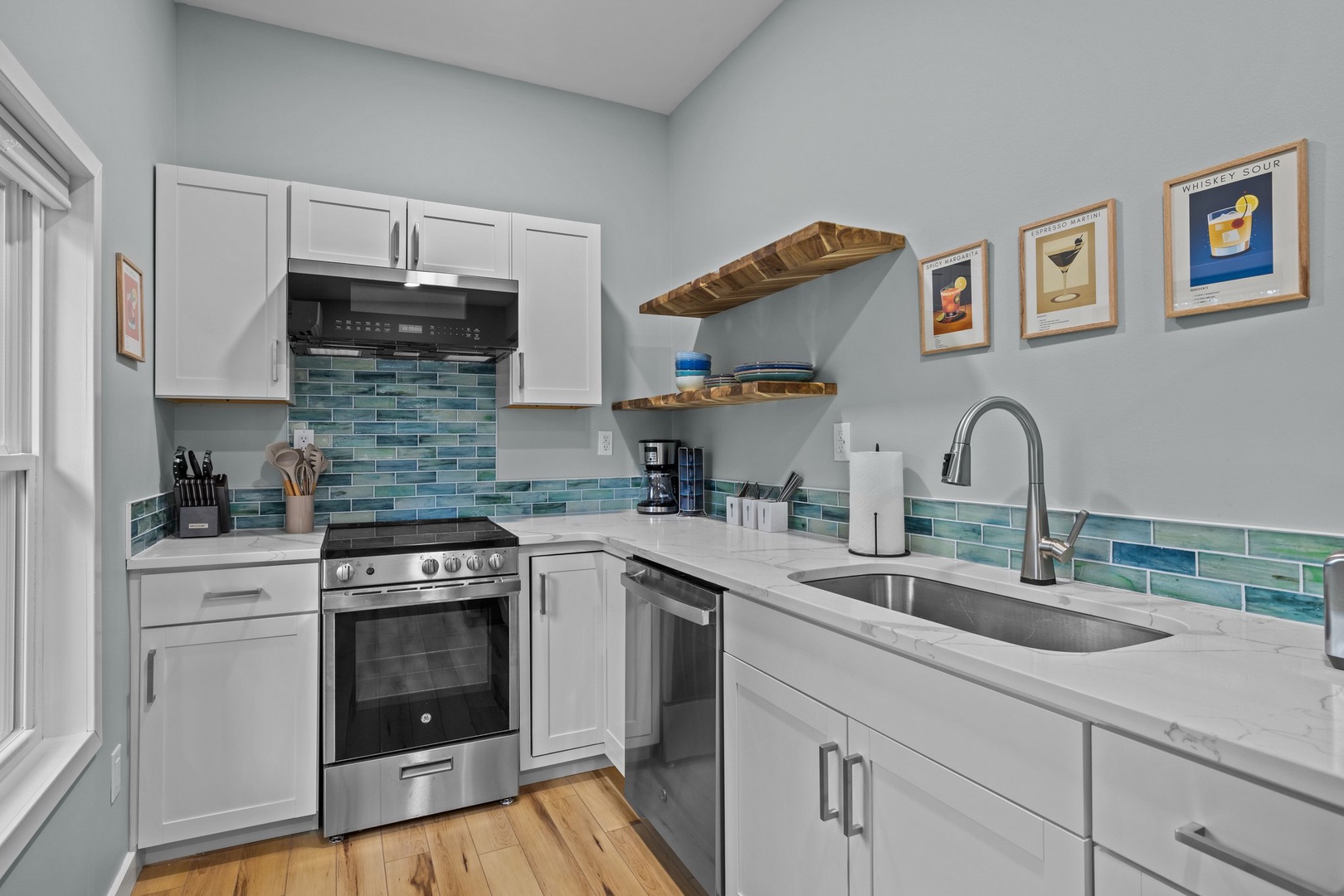 Your fully equipped kitchen features modern appliances, ocean-inspired tile backsplash, and everything you need to create memorable meals together.