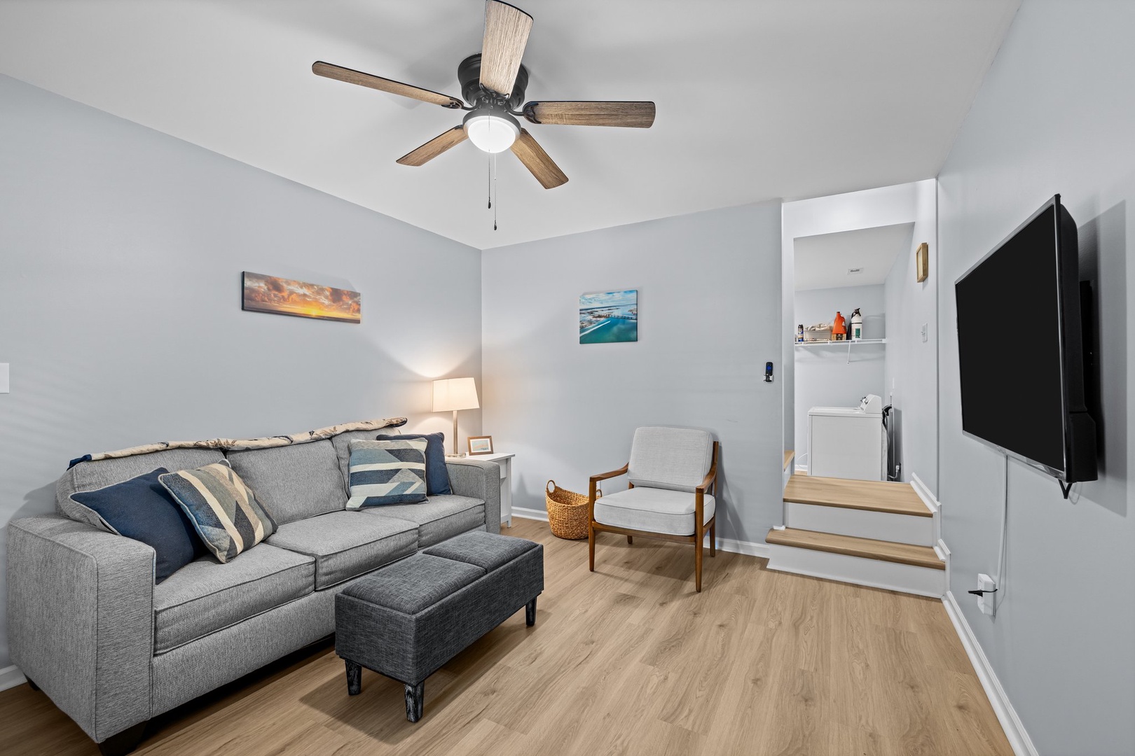 Relax in your bright living room with cozy gray sectional, ceiling fan, and flat-screen TV for perfect evening entertainment.