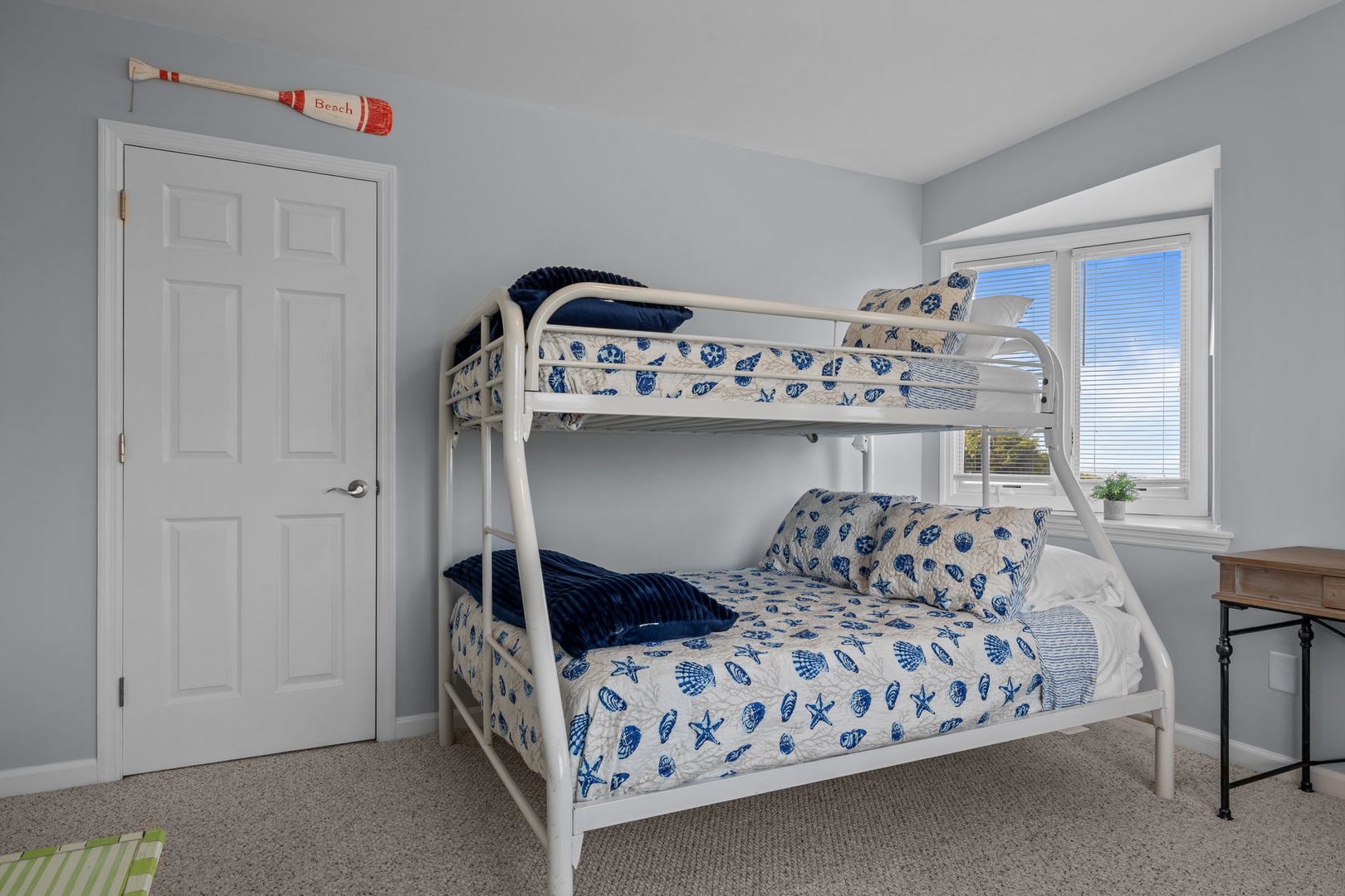 Your kids will love this cozy nautical-themed bunk room with twin-over-full beds, perfect for bedtime stories and morning adventures.