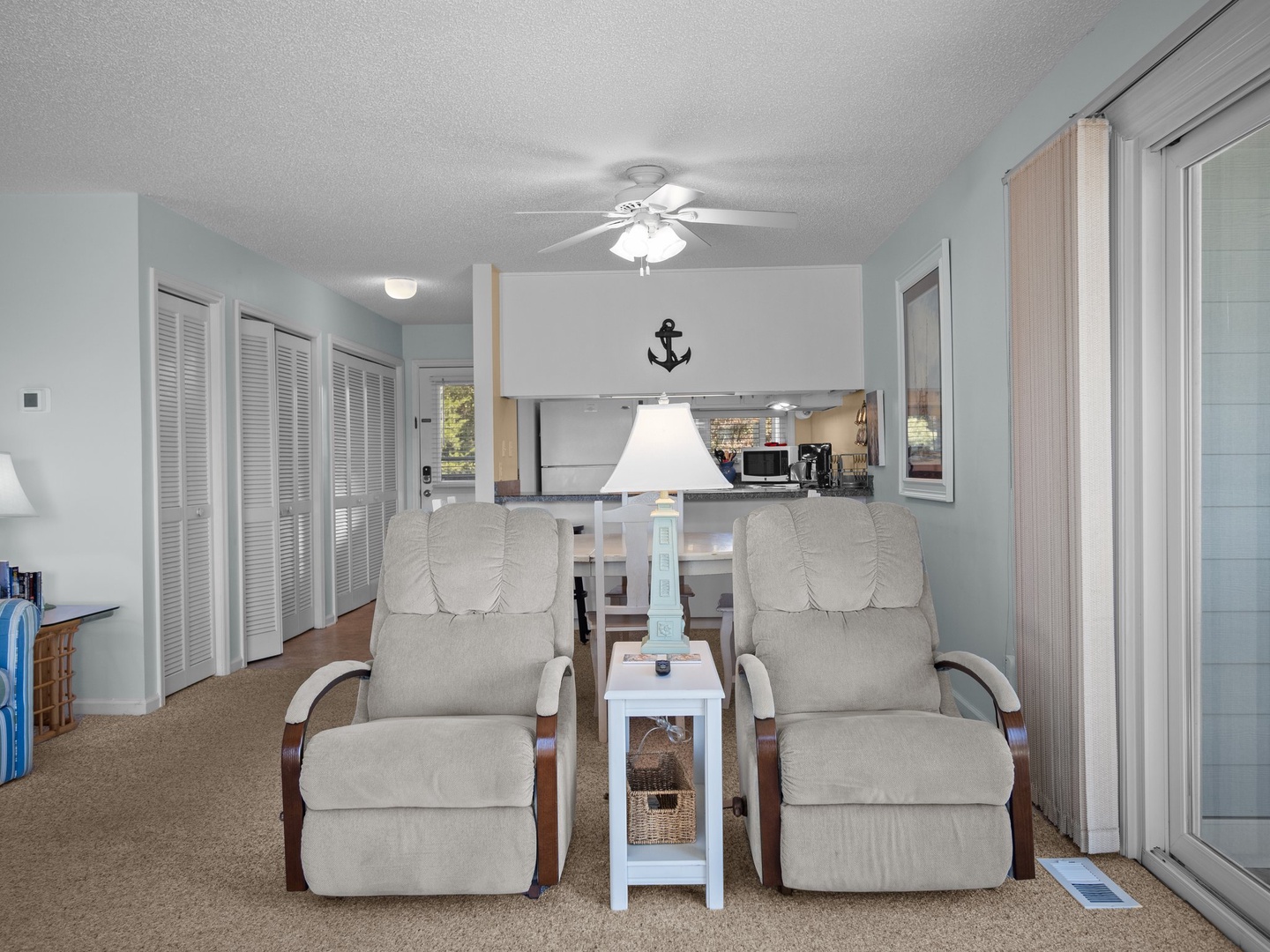 Unwind in your coastal living room with comfortable recliners perfect for relaxing after beach days. The open layout connects to your kitchen.