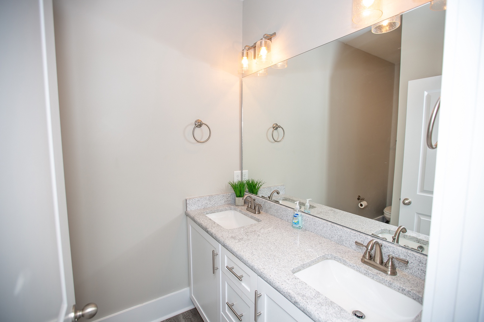 Your spacious bathroom features elegant dual vanities with granite countertops and warm lighting for a luxurious start to each morning.