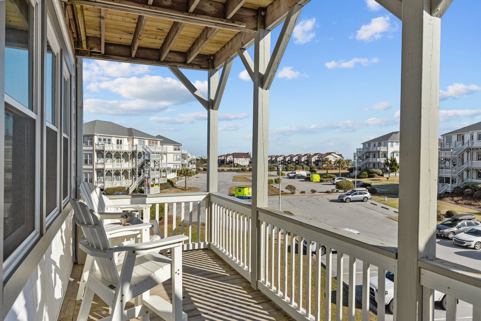 Step onto your covered balcony and breathe in the fresh coastal air while enjoying comfortable seating with neighborhood views.