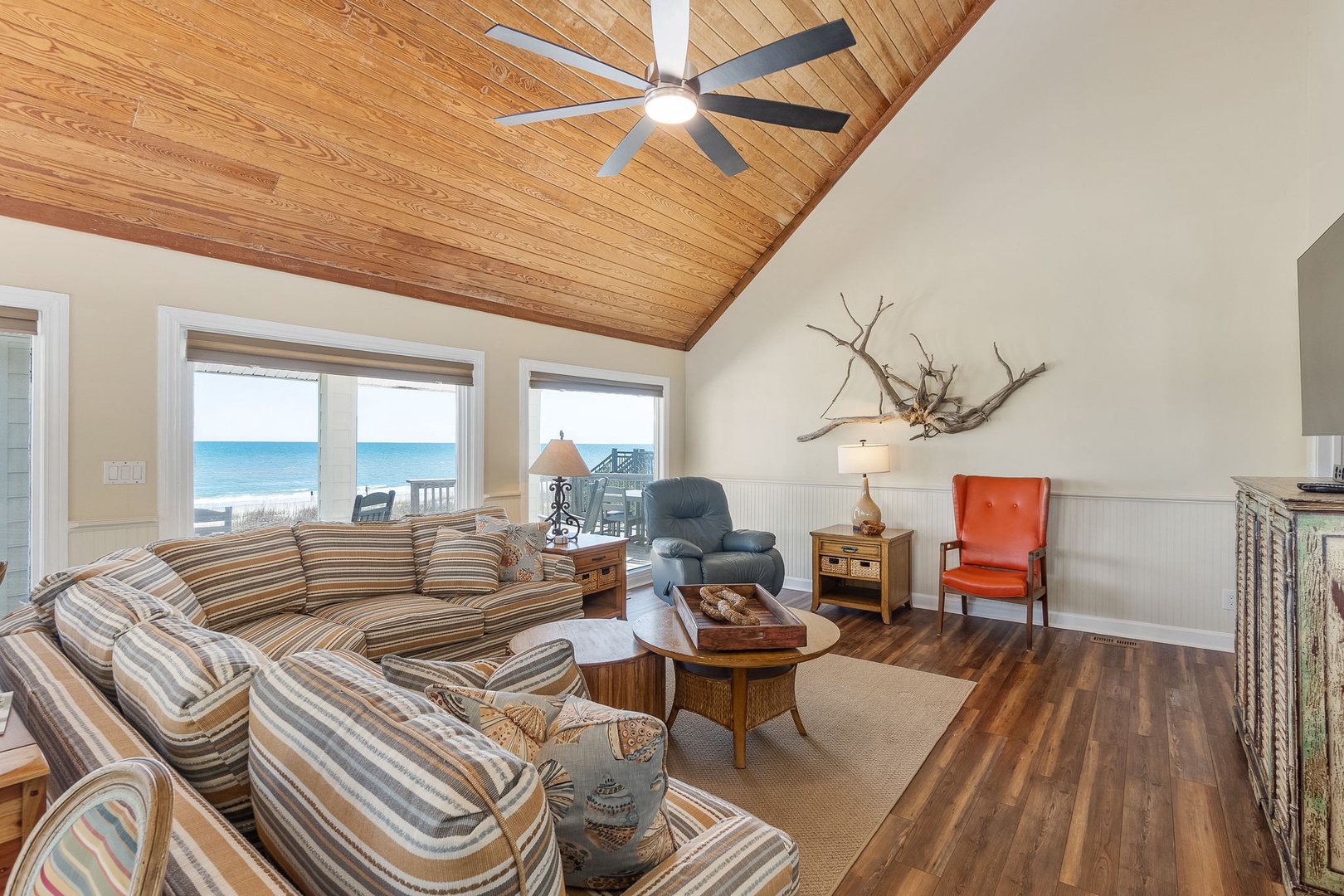 Relax in your coastal living room where warm wood tones meet ocean views, creating the perfect beachside retreat.