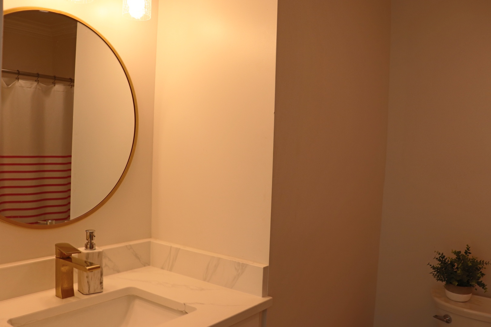 Step into your stylish bathroom with sleek marble counters, modern fixtures, and a striking round mirror that creates an elegant start to your day.