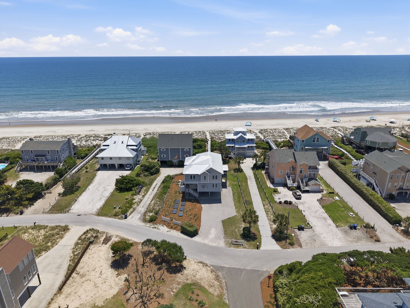 Beachfront community featuring coastal homes with direct beach access and expansive ocean views along a sandy shoreline.