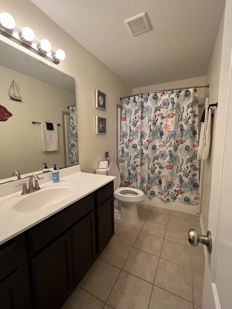 Your private bathroom features elegant floral wallpaper, modern fixtures, and thoughtful touches that make your daily routine feel luxurious and refreshing.