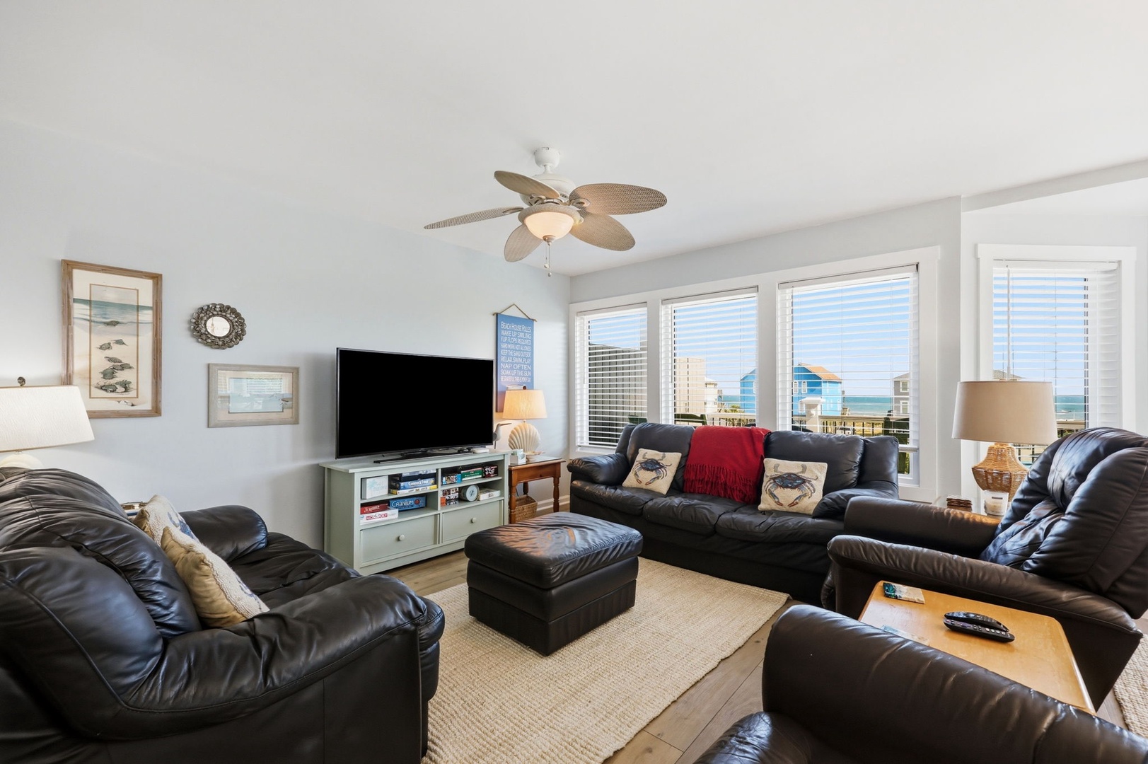 Sink into plush leather sofas and enjoy stunning ocean views through expansive windows in your inviting living room retreat, complete with beach-inspired décor and modern entertainment.