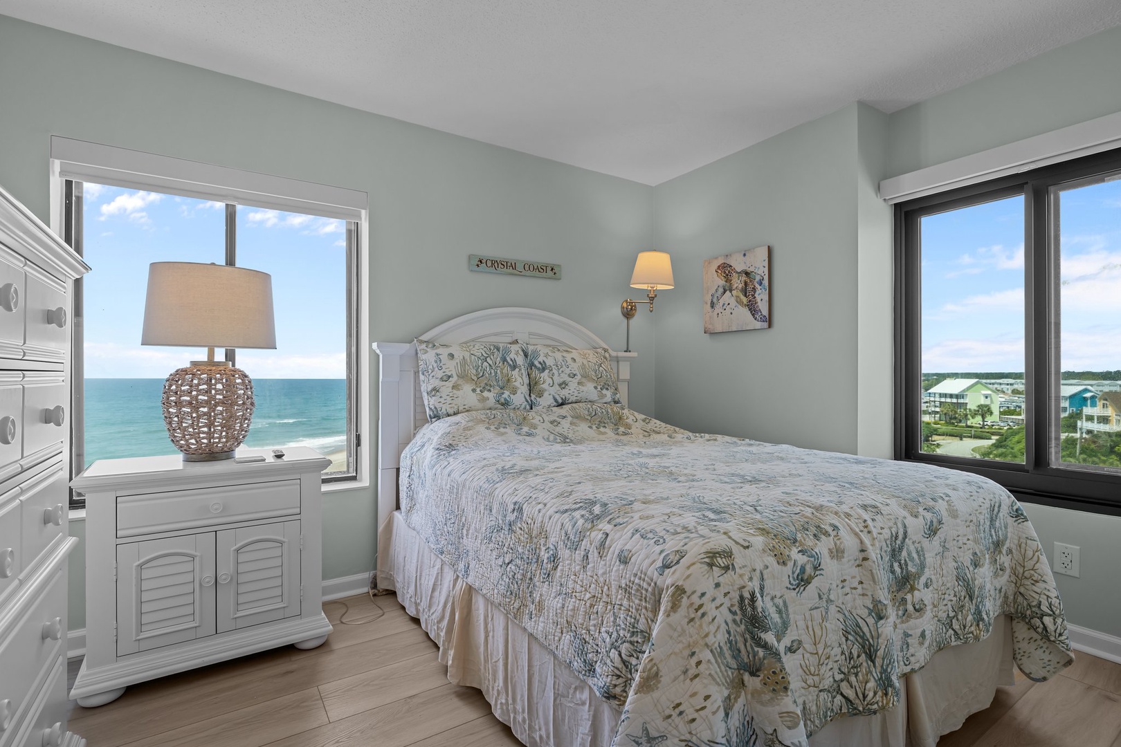 Wake to stunning ocean views from your coastal bedroom, where sea breezes flow through large windows and beach-themed linens invite peaceful rest.