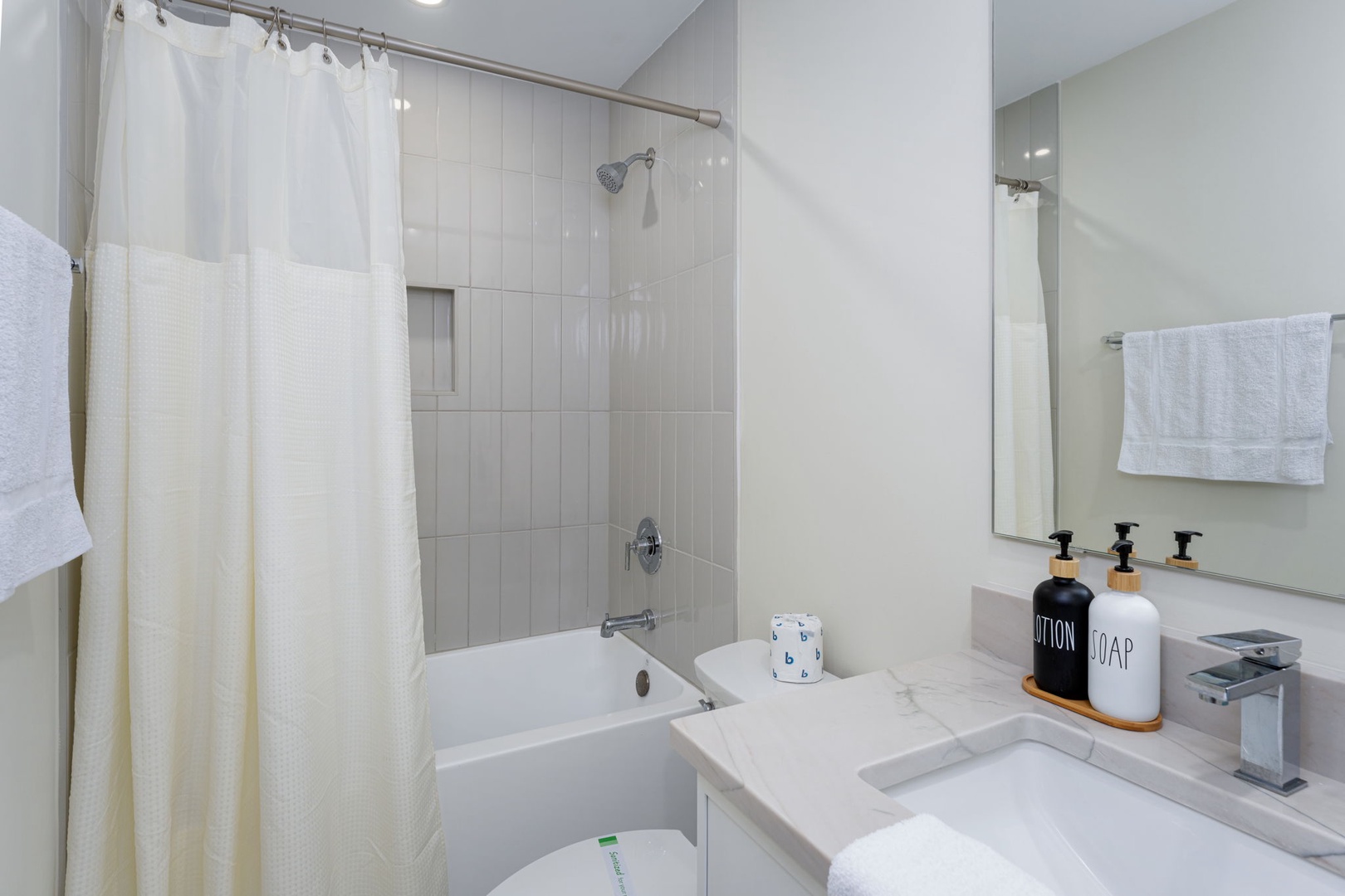 Your pristine bathroom features a luxurious soaking tub with rainfall shower, elegant marble countertops, and premium toiletries for ultimate relaxation.