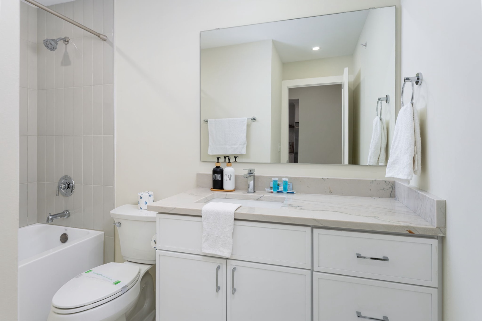 Your modern bathroom offers everything for a refreshing stay with marble counters, fluffy towels, and a luxurious tub-shower combo.