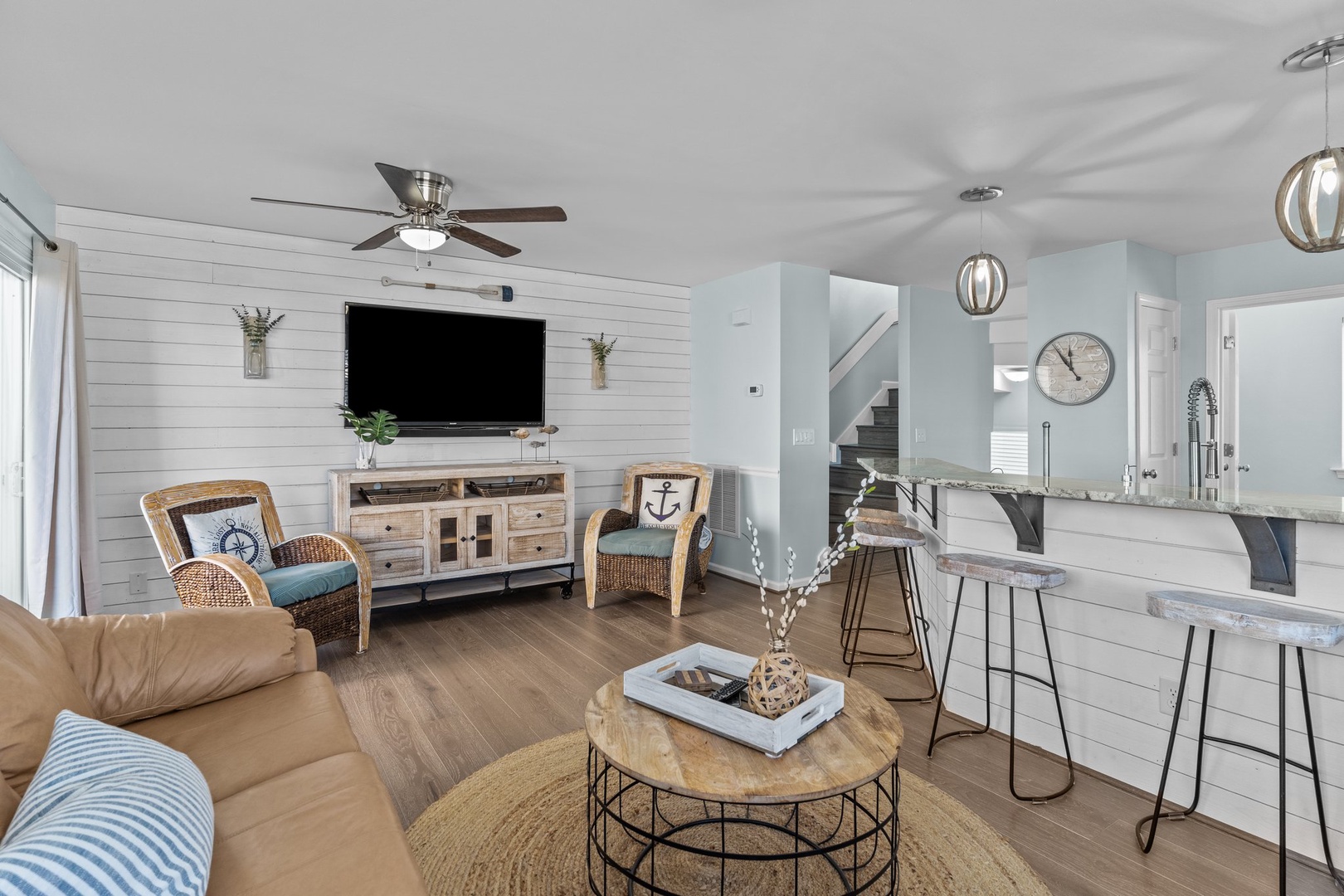Relax in your coastal-inspired living space featuring shiplap walls, modern kitchen island, and nautical touches throughout.