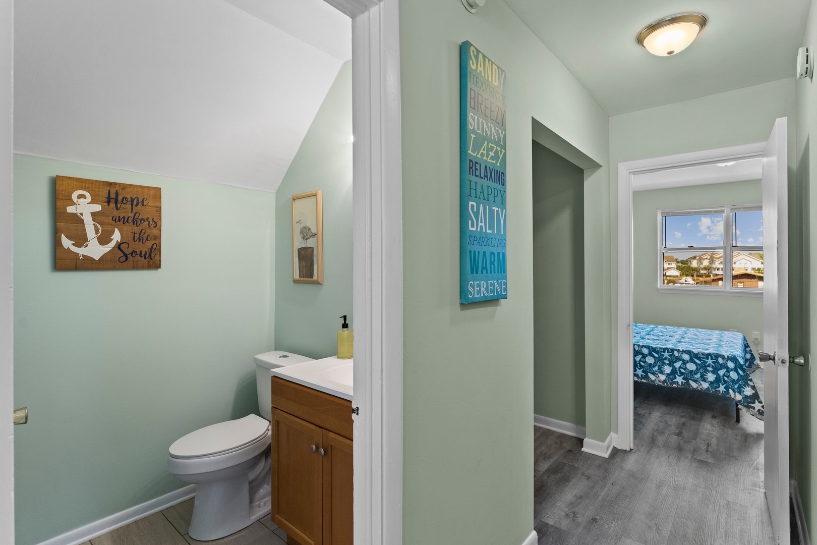 Your coastal-themed bathroom features calming sea-green walls and charming nautical decor, creating a peaceful retreat after beach adventures.