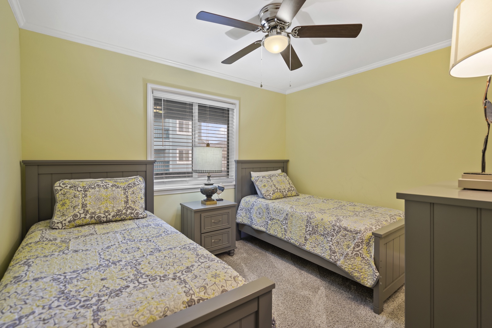 Unwind in your comfortable twin bedroom with cheerful decor and peaceful natural light flowing through the window.