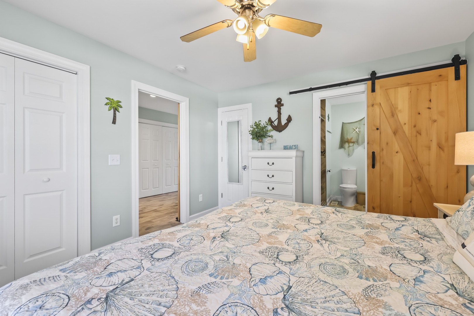 Relax in your coastal-inspired bedroom with nautical touches and a charming barn door leading to your private bathroom. The soft bedding and beachy decor create a serene retreat.