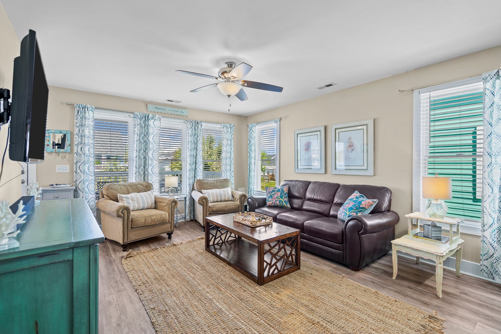 Relax in your bright living room with leather sofa, cozy armchairs, and entertainment center—perfect for unwinding after your adventures.