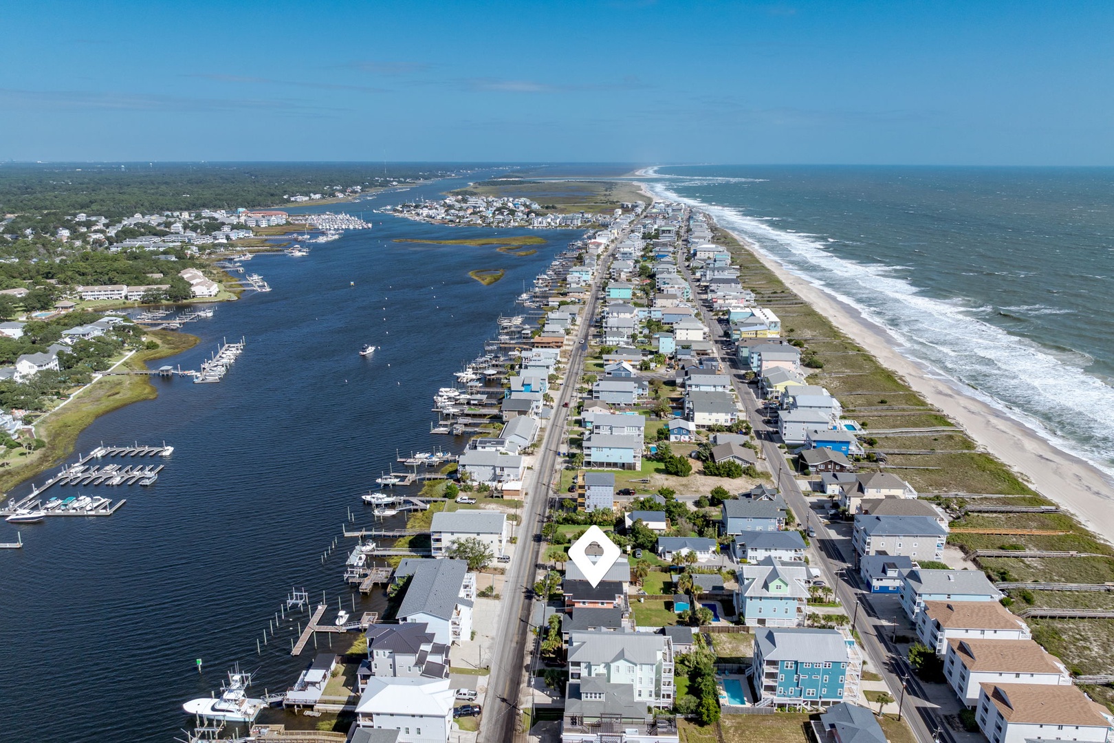 Stunning coastal community featuring pristine beaches, marina access, and waterfront homes stretching between bay and ocean.