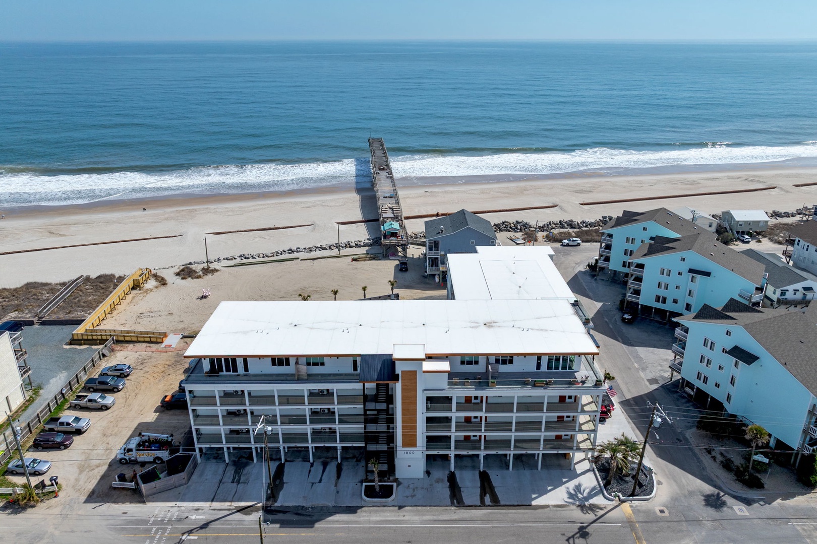 Beachfront property situated directly on pristine sandy shores with rolling waves and coastal charm.