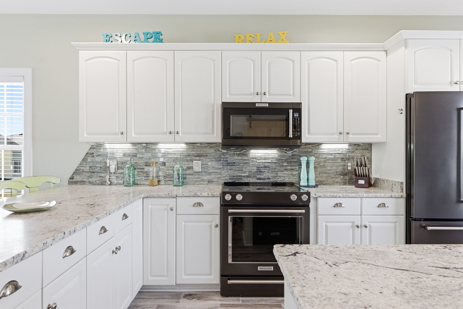Your fully equipped kitchen invites culinary adventures with sleek granite counters, modern appliances, and a charming coastal vibe set by the decorative touches and bright, airy ambiance.